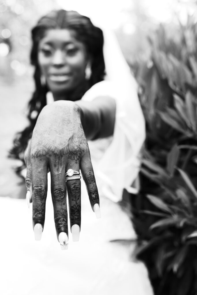 main de mariée mettant en avant sa bague de fiançailles et son alliance en gros plan