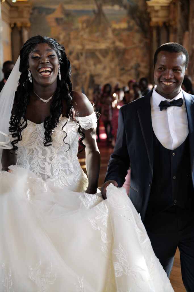 photographie d'un couple de mariés souriant et heureux sortant du Capitole de Toulouse après la cérémonie.