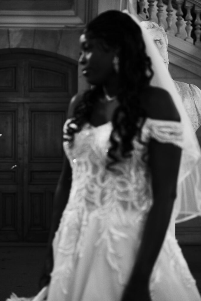 Photographie d'une mariée de profil, perdue dans ses pensées au capitole de Toulouse, en noir et blanc.