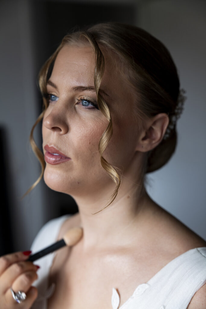 Portrait d’une mariée en pleine mise en beauté avant la cérémonie, regard intense et lumière naturelle. Photo de préparatifs de mariage capturée avec élégance à Toulouse.