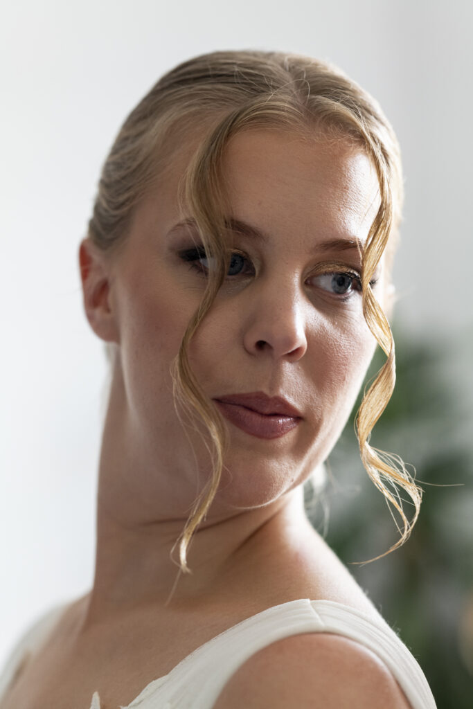 Portrait serré d’une mariée se regardant dans un miroir, capturant un moment intime de ses préparatifs.